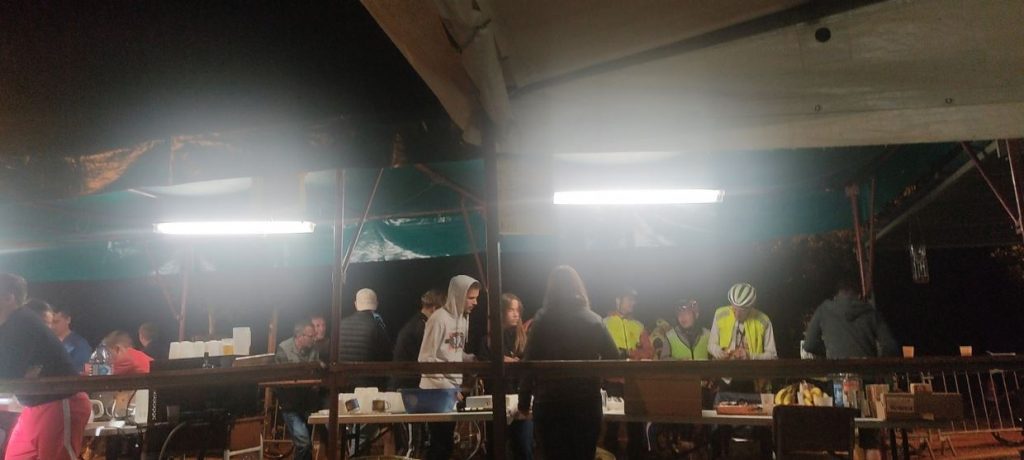 Cyclists and locals mixed together at a night time pop-up cafe